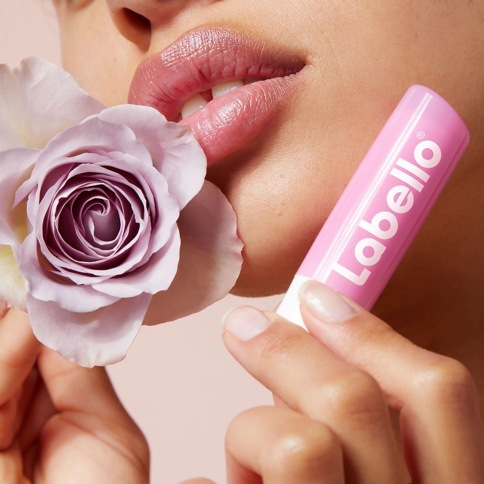 Vrouw met roze lippenbalsem - Labello