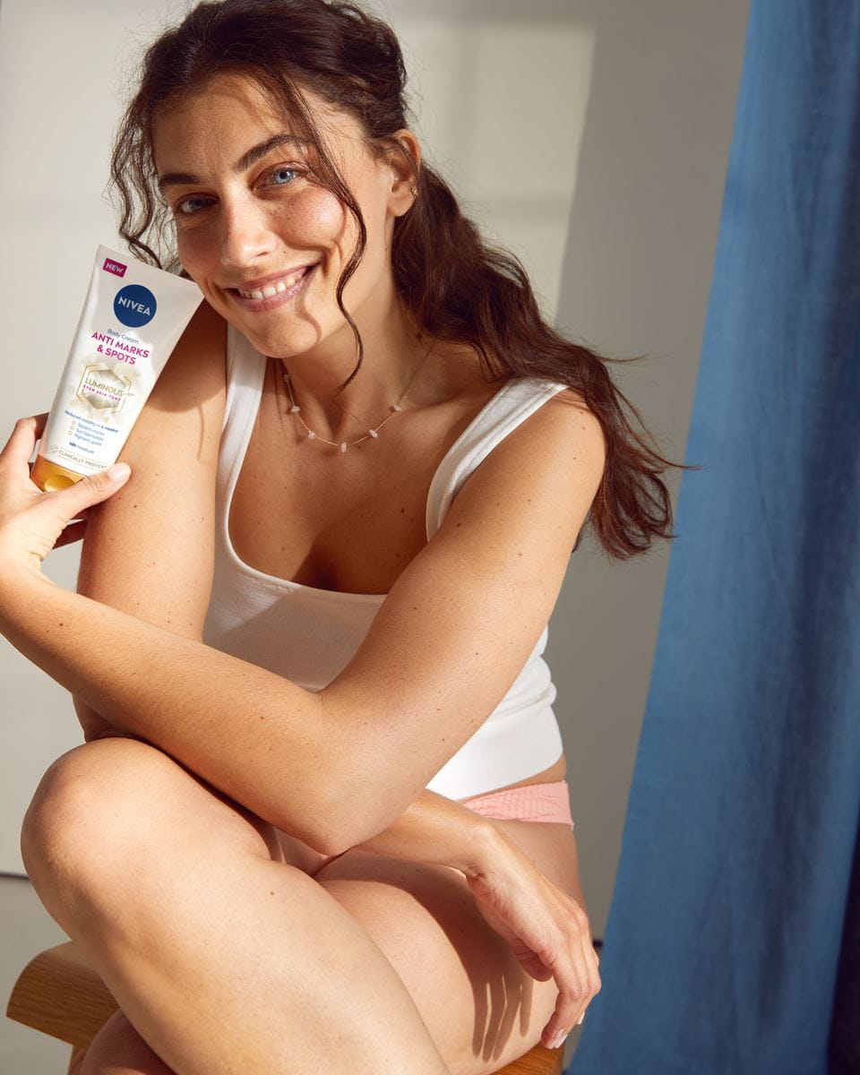 jonge vrouw die Nivea Luminous Anti-striae gebruikt