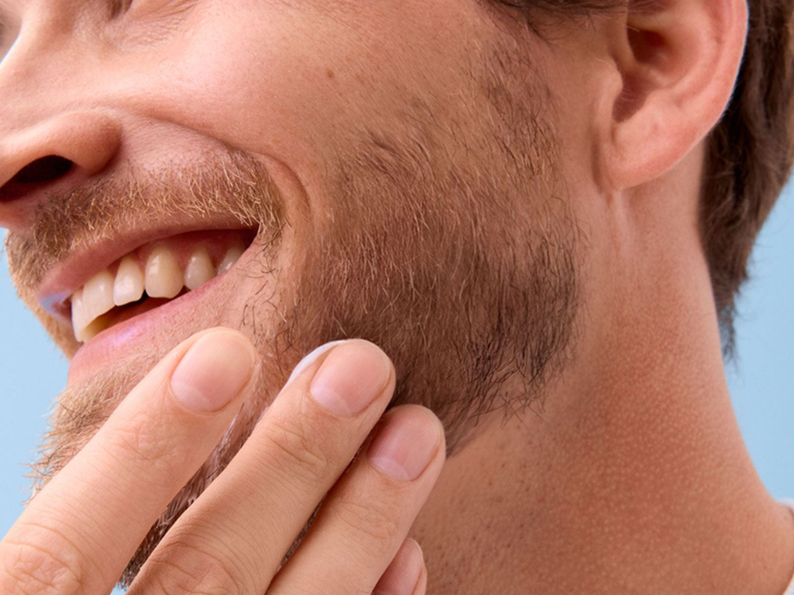 Close-up view of a person holding their chin while smiling.