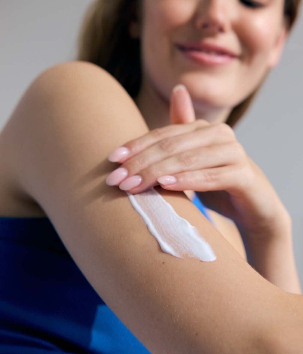 Woman applying express hydration lotion on her arms