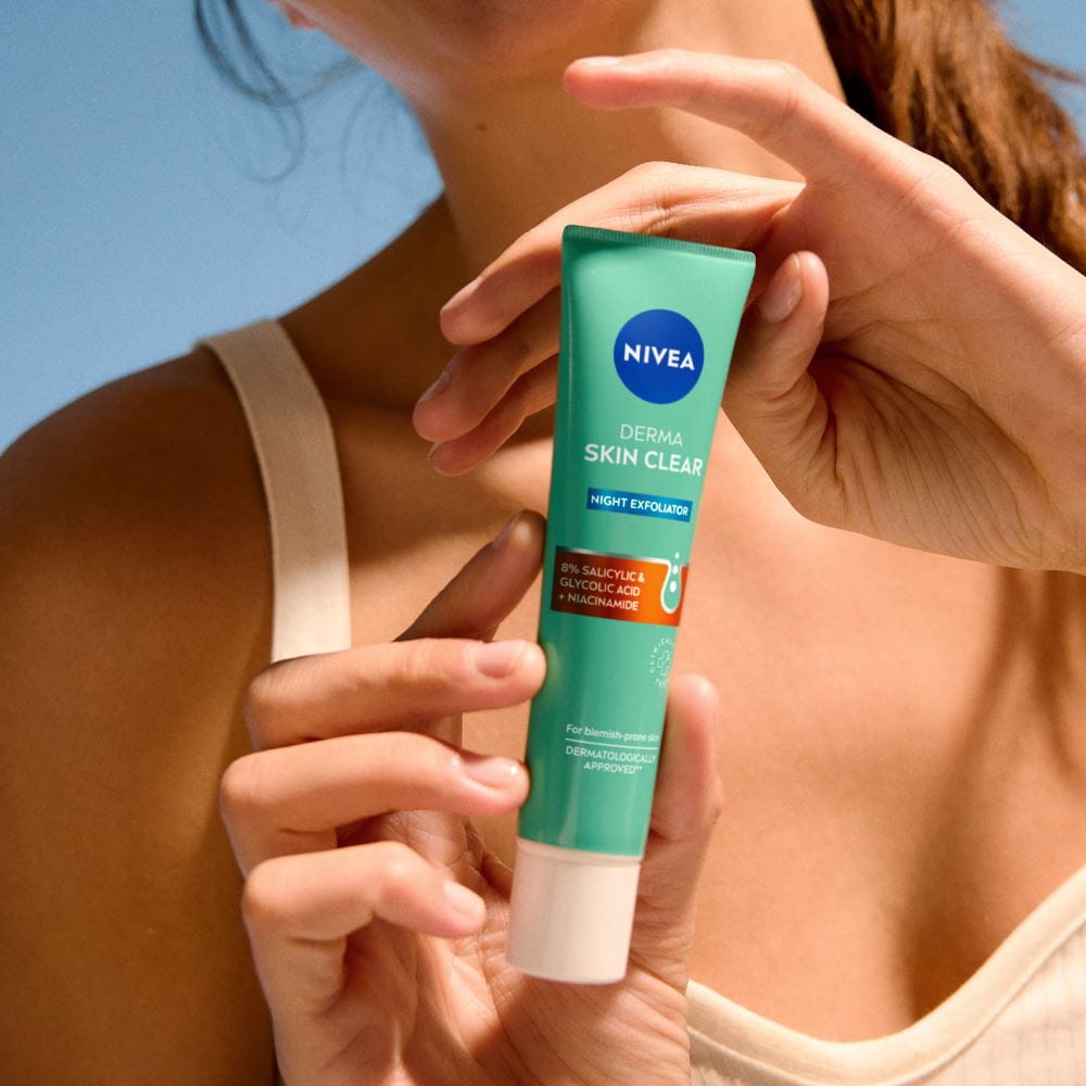 NIVEA Derma Skin Clear Нощен пилинг лежи върху полица в банята.