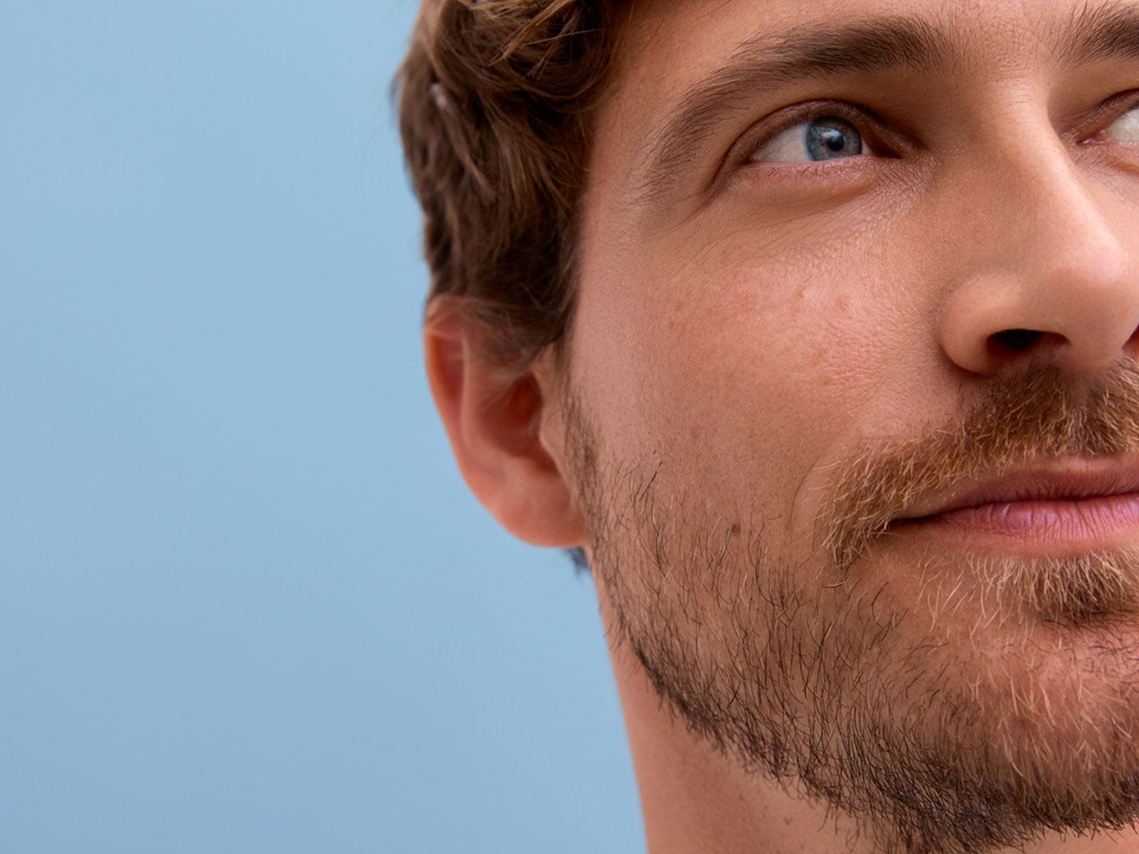 View of a person looking off into the distance, against a blue background.