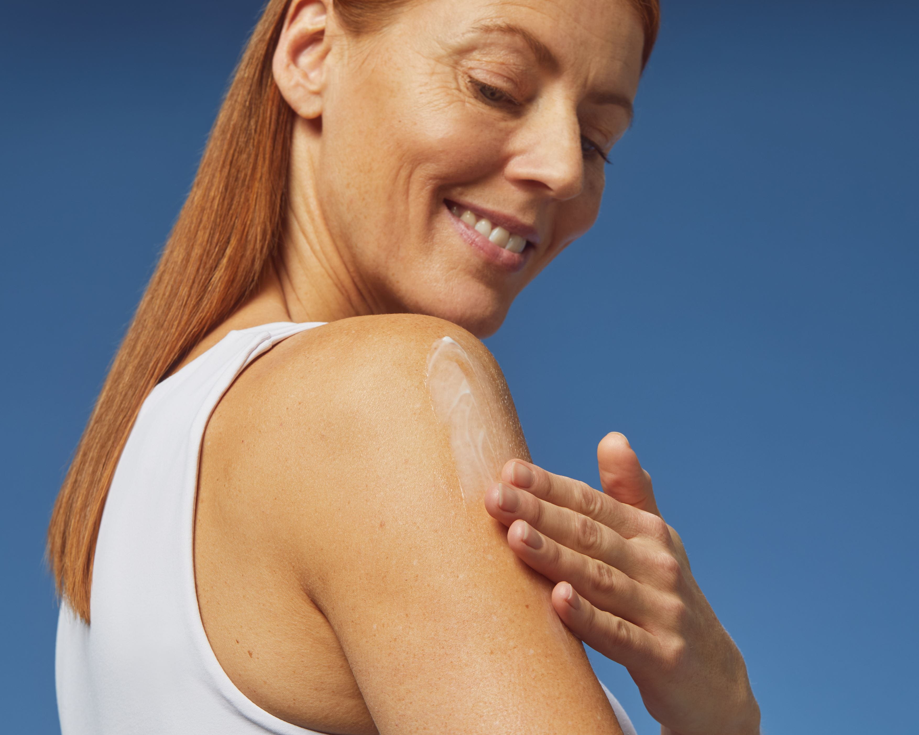 young woman using  NIVEA lotion on her arm