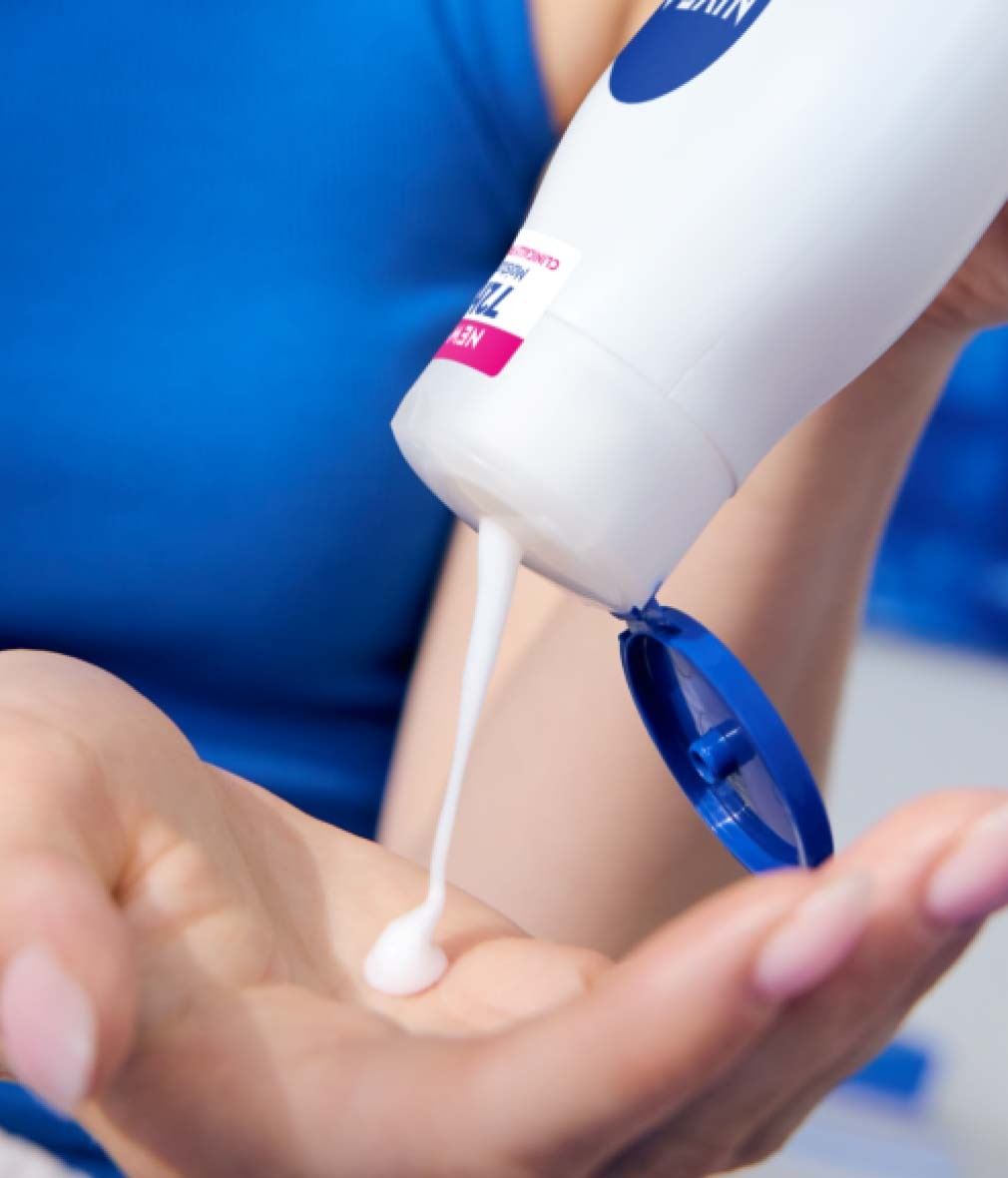 Woman pouring NIVEA Express hydration body lotion in her palm