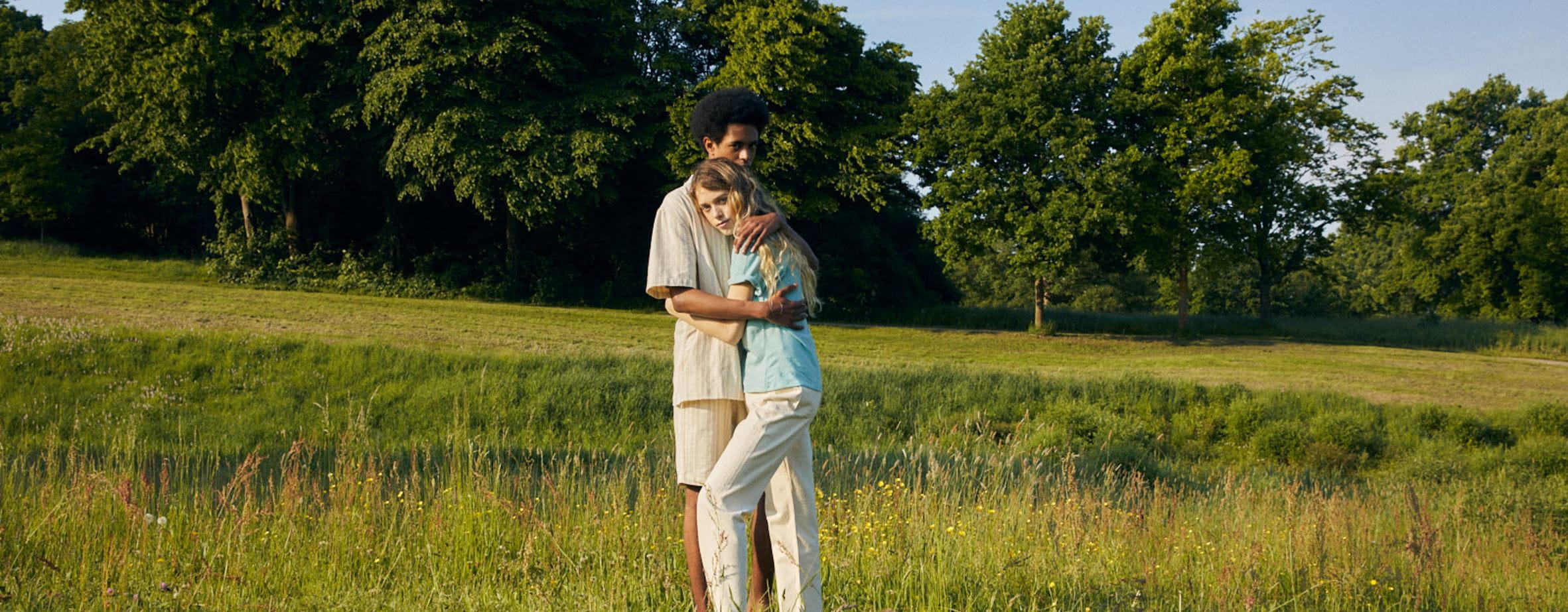 hands holding in a field of long grass