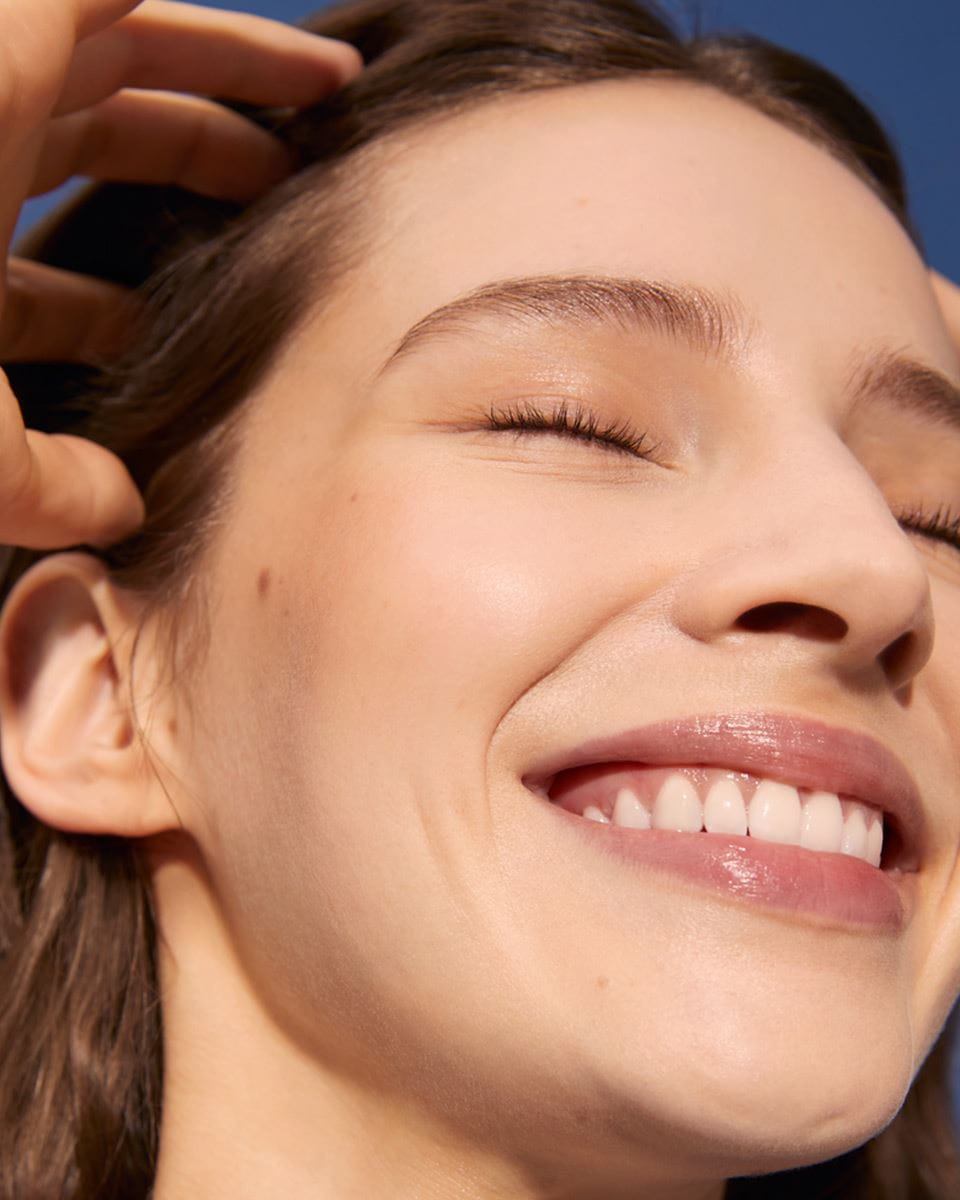 Vue d'une personne souriant les yeux fermés.