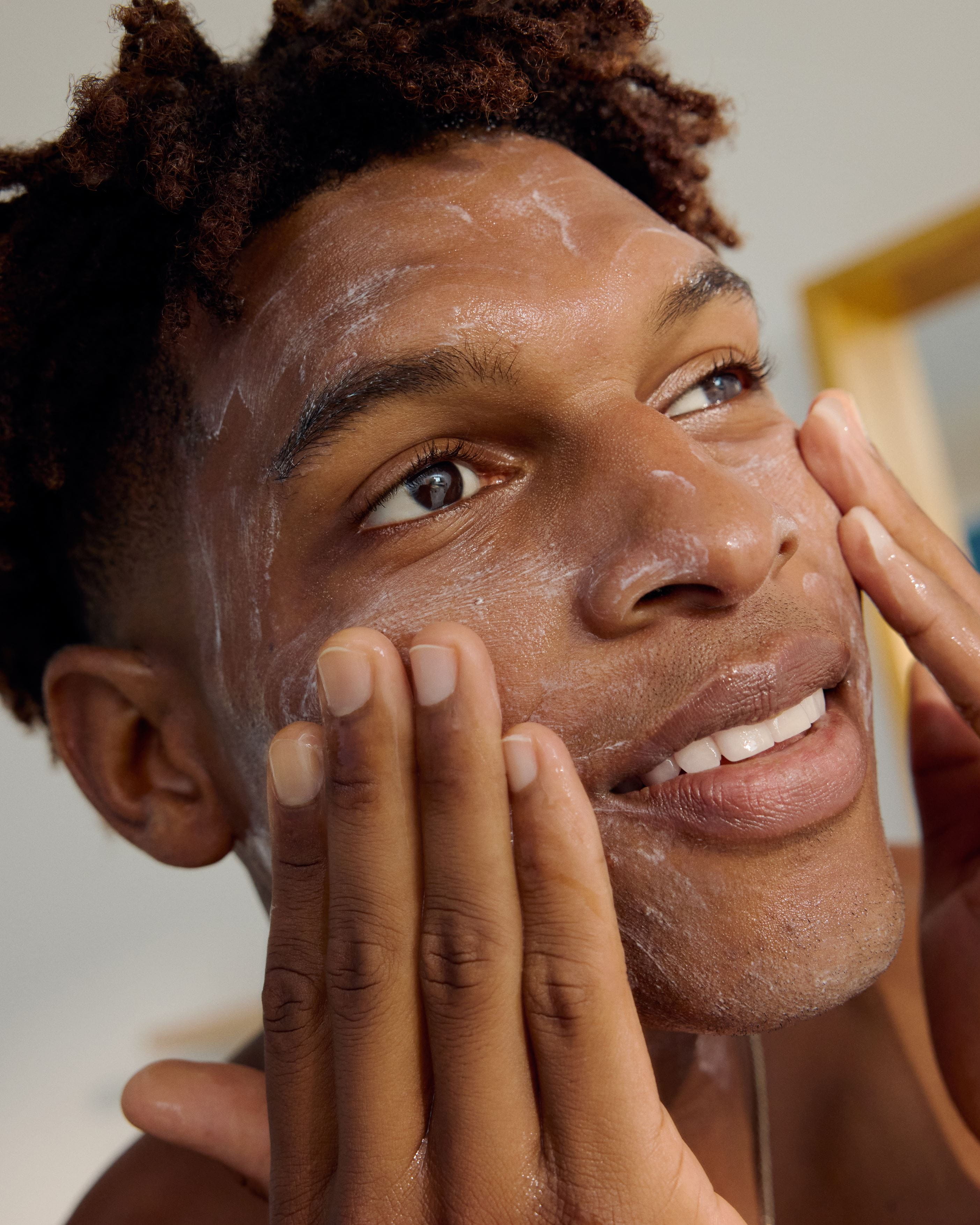 Un joven aplicando gel de lavado Nivea en la cara