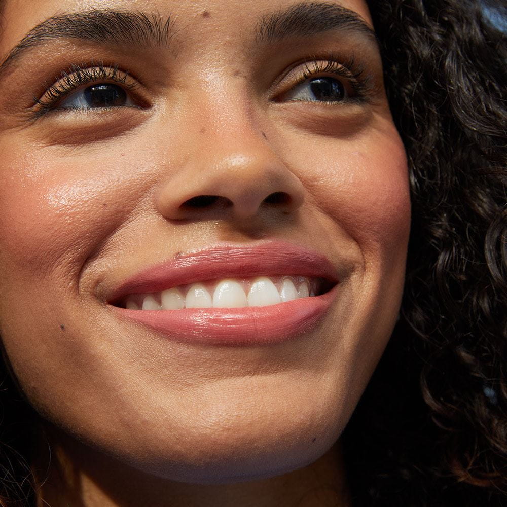 A person seen smiling while gazing off into the distance.