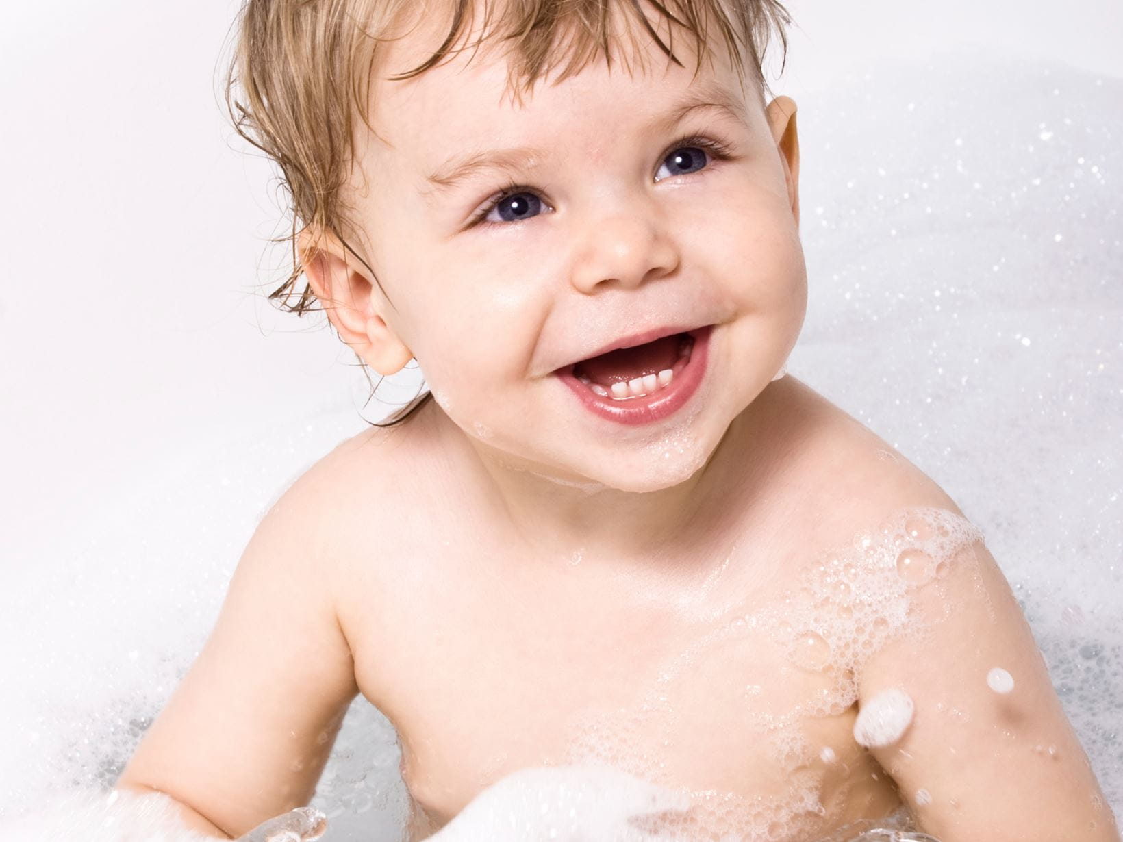 Un enfant qui rit dans un bain moussant