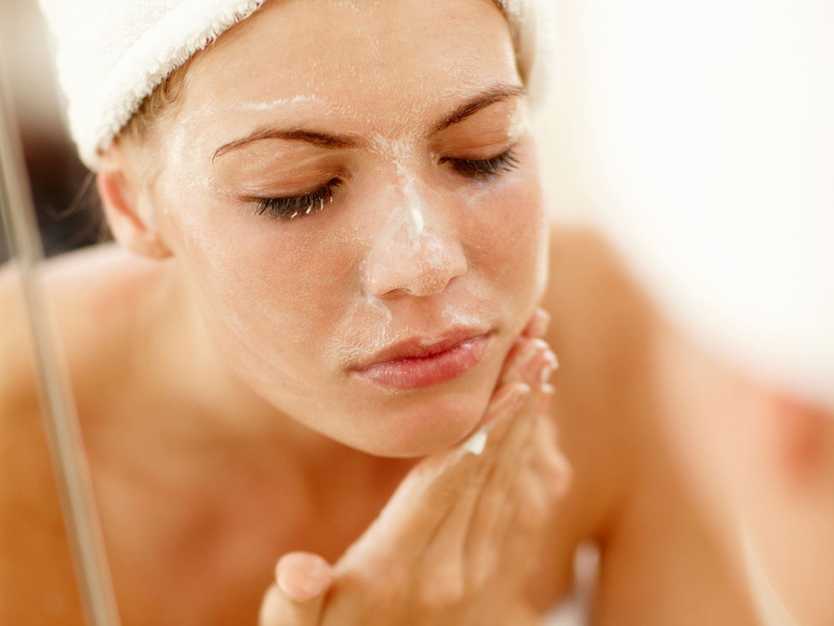 woman washing her face with vegan skincare product
