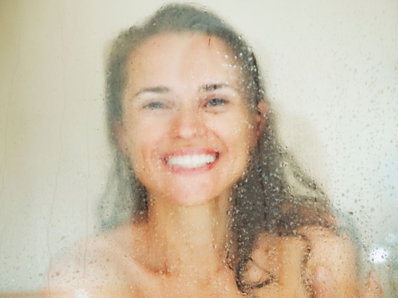 smiling-young-woman-behind-shower-door