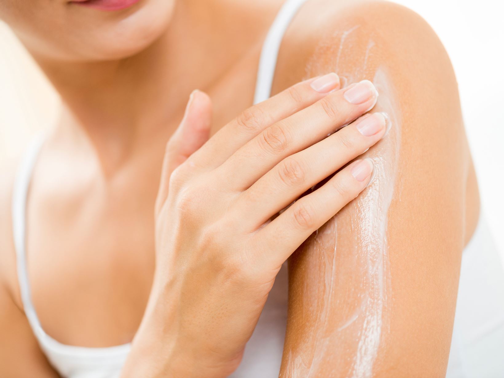 woman-applying-cream-on-arm
