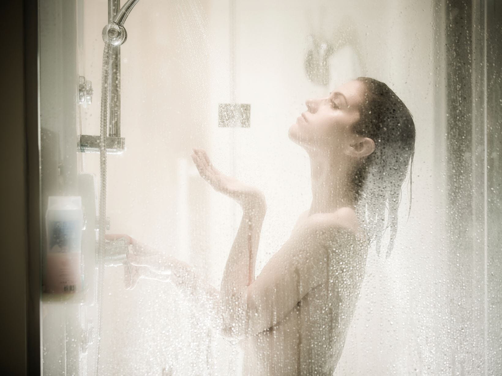 woman avoiding dead skin cells on face in shower