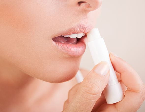 lady applying lip balm after exfoliating her lips