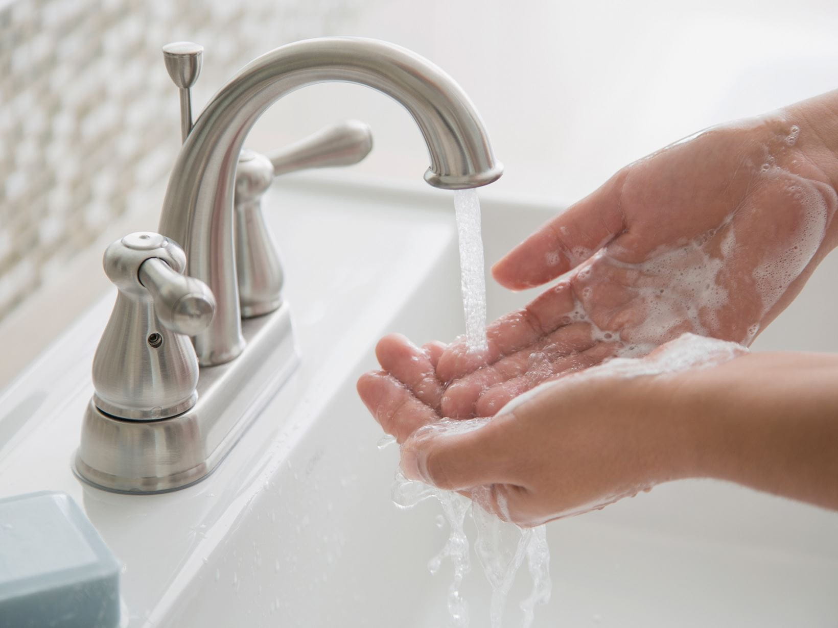 nő mosás kezét a fürdőszoba mosogató