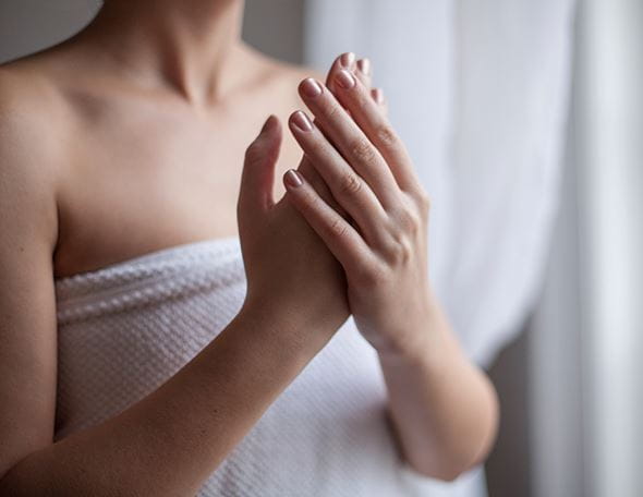 lady touching her sweaty hands while wearing a towel
