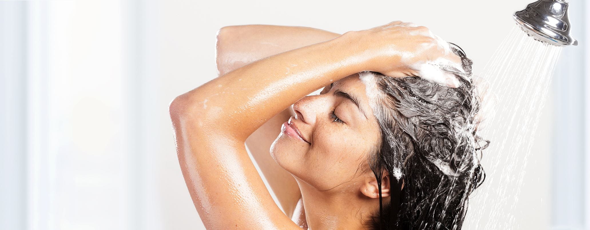 Femme se lave cheveux sous la douche