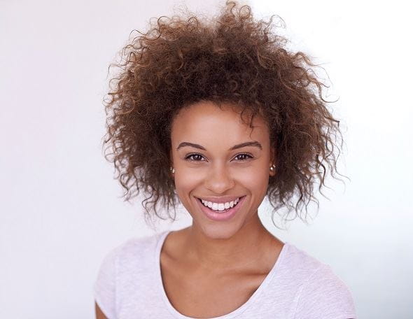 lady with curly hair smiling at the camera