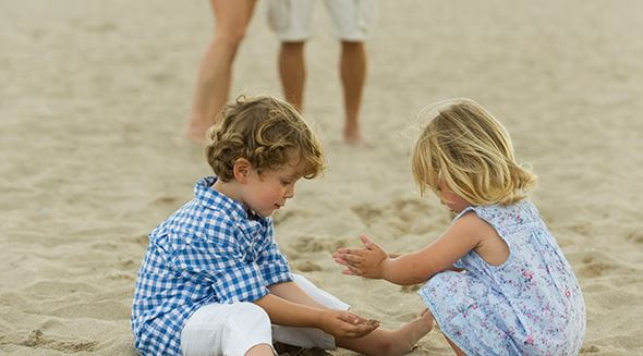 crianças a brincar na areia da praia