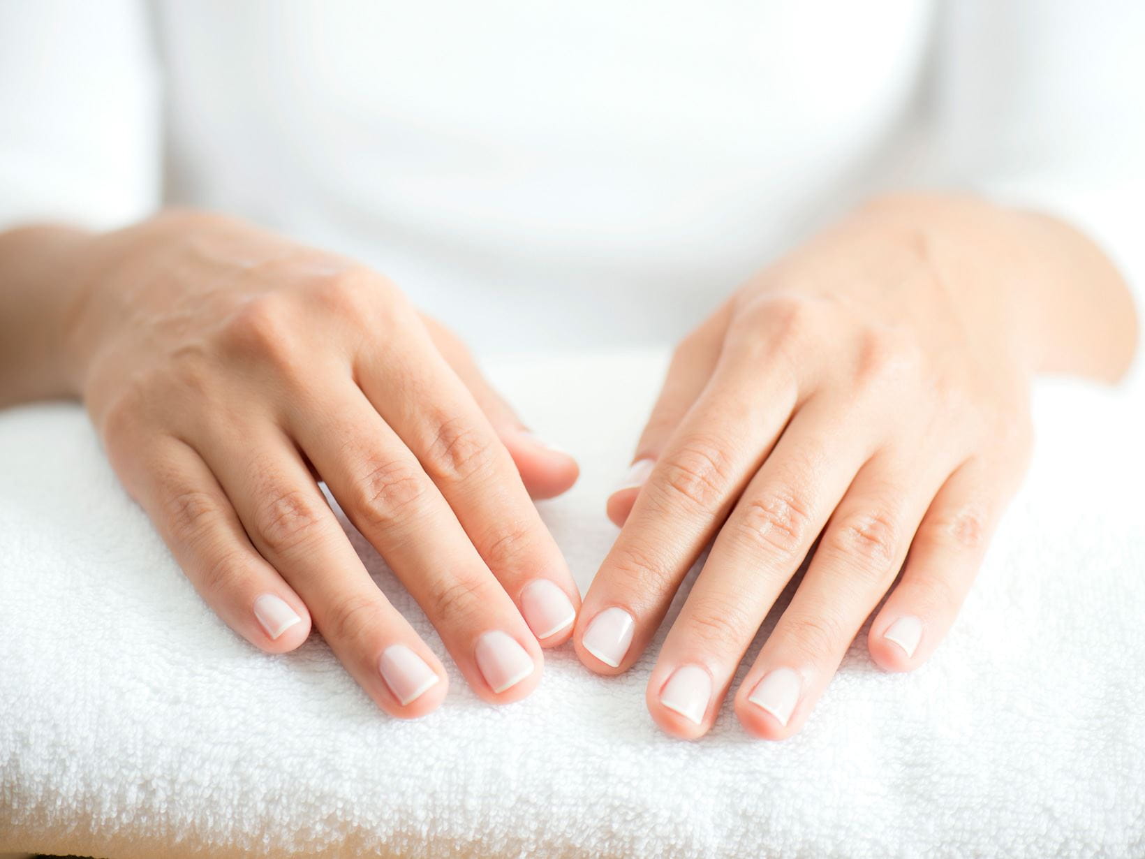 smukke-hænder-og-rene-negle-på-håndklæde