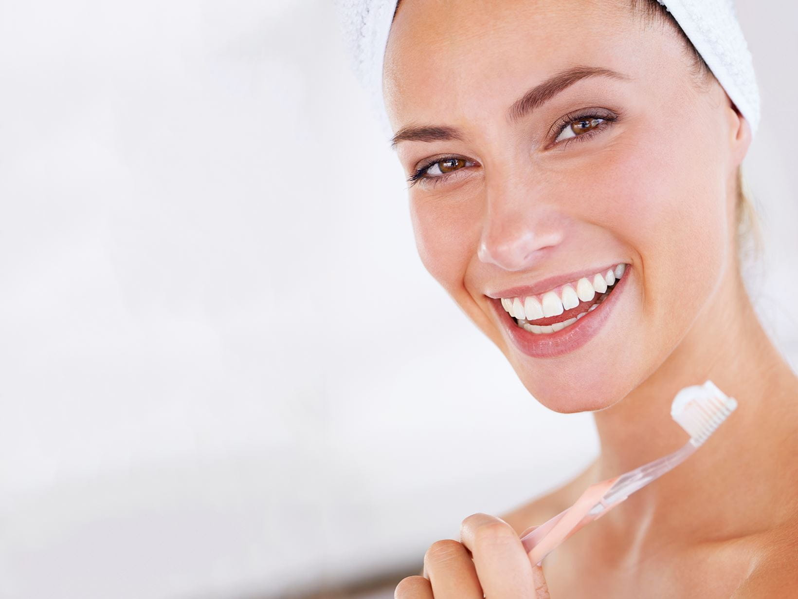 mulher a sorrir com escova de dentes