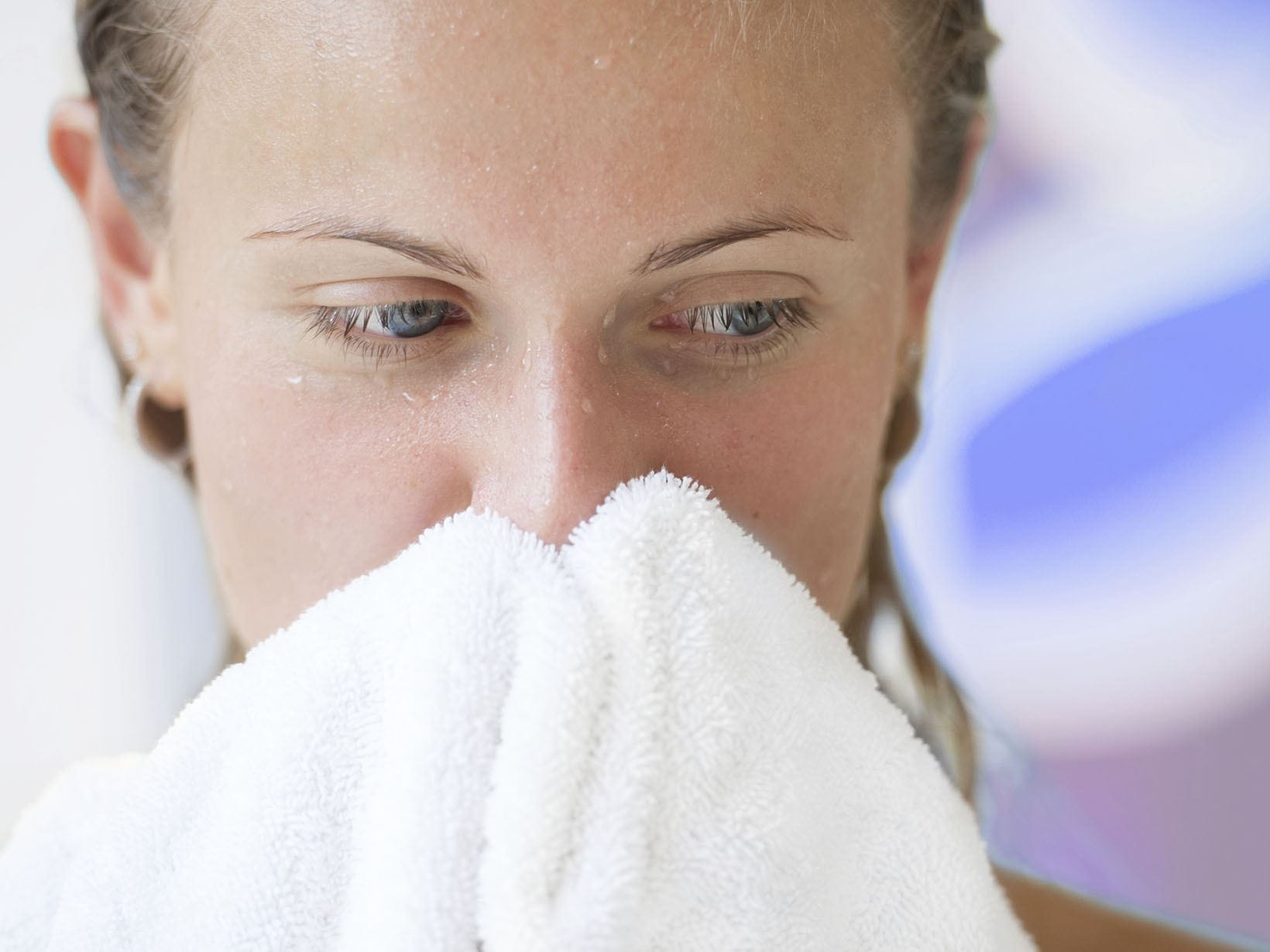 limpar o rosto com a toalha