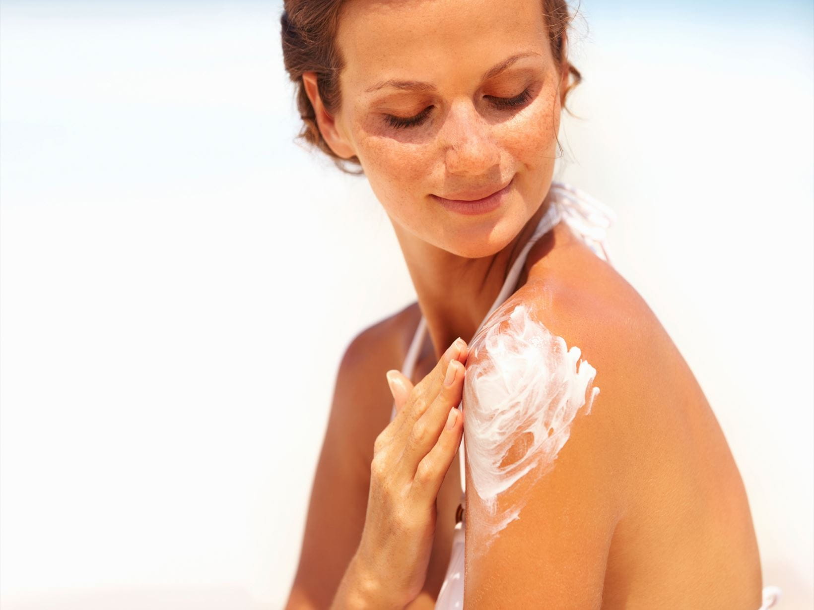 mulher a aplicar protetor solar para pele sensível