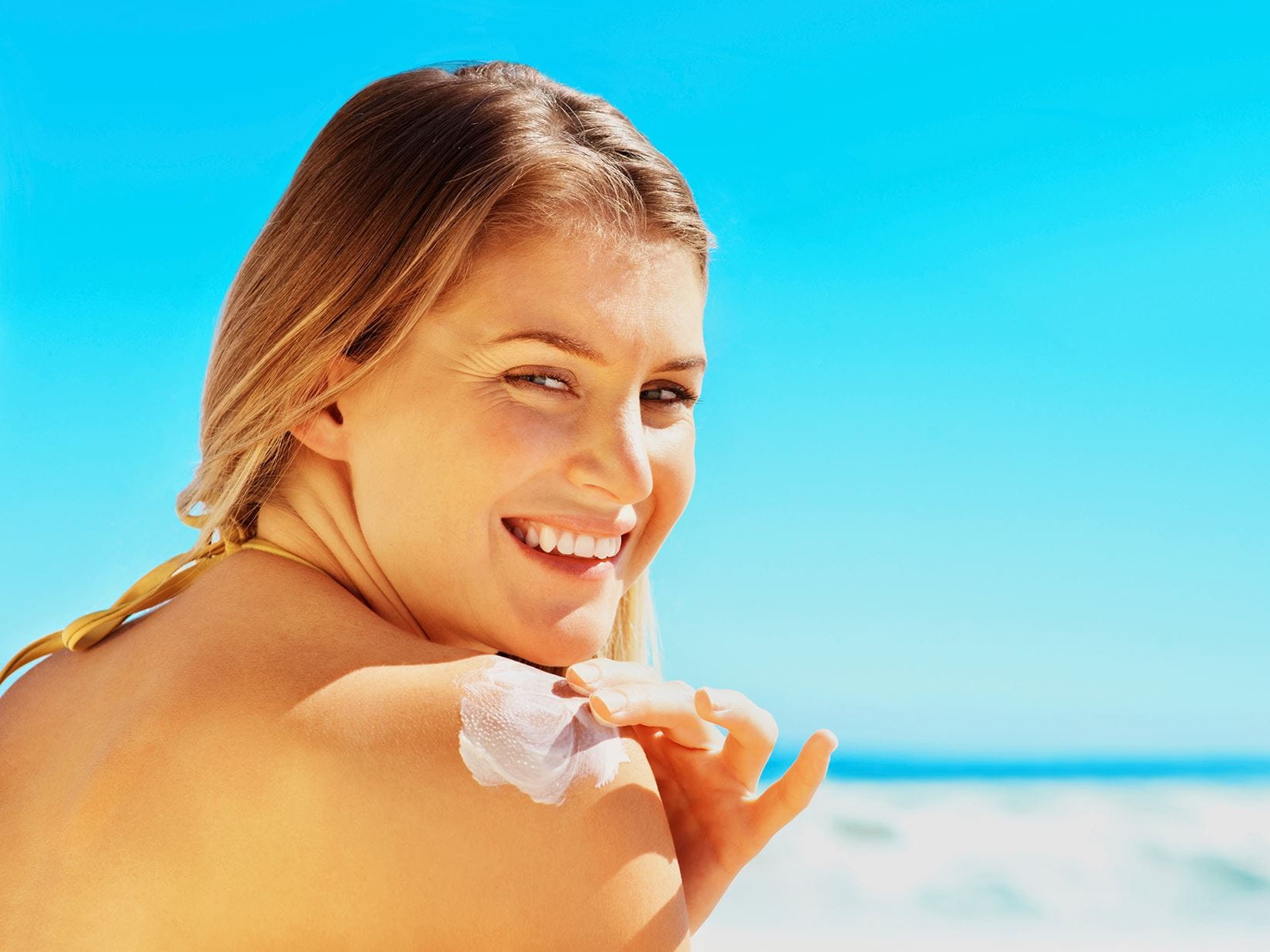 woman smiling with suncream on