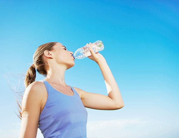 woman drinking water in sun
