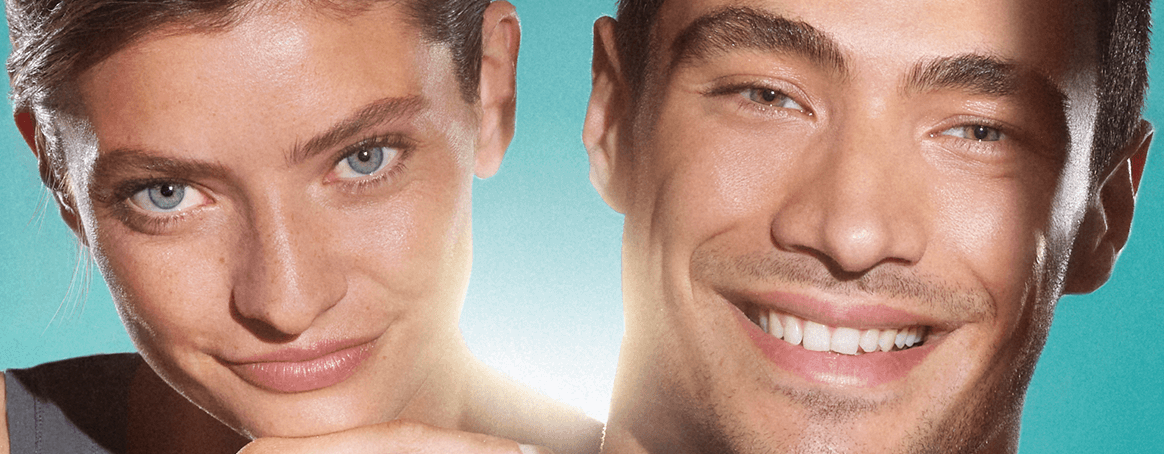 Medium close up of a woman and man, both of their faces show clear, blemish-free skin. They
