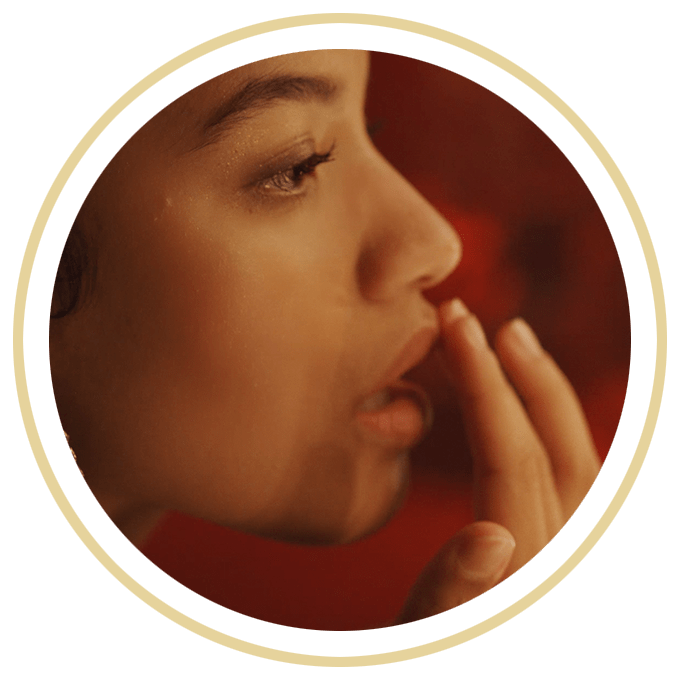 Vue de profil du visage d’une femme appliquant du beurre à lèvres NIVEA à l’aide de son doigt.