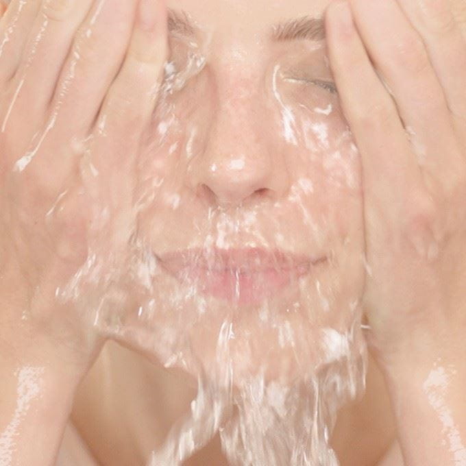 woman-rinsing-face-with-water