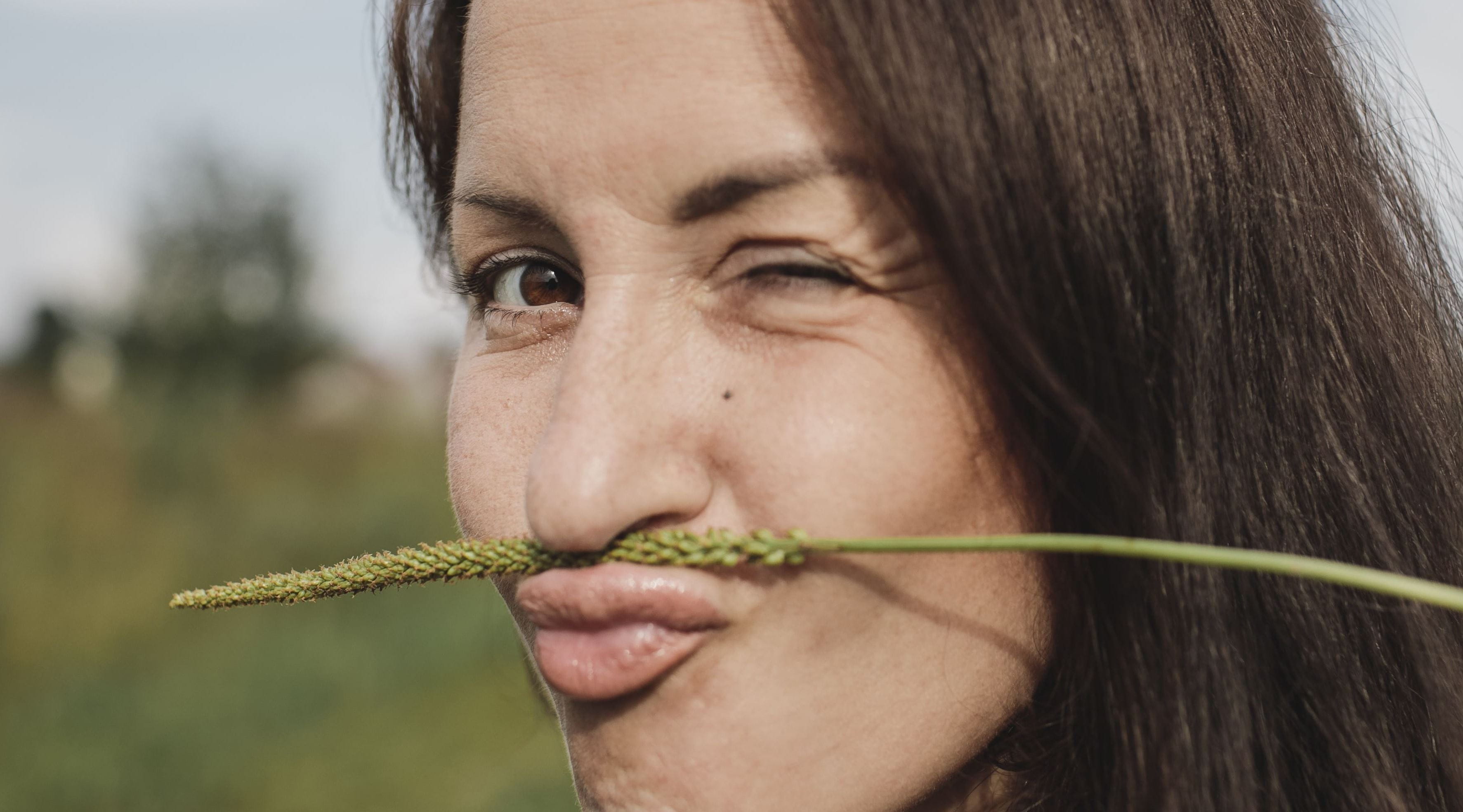 mulher com uma planta seca a fazer de bigode