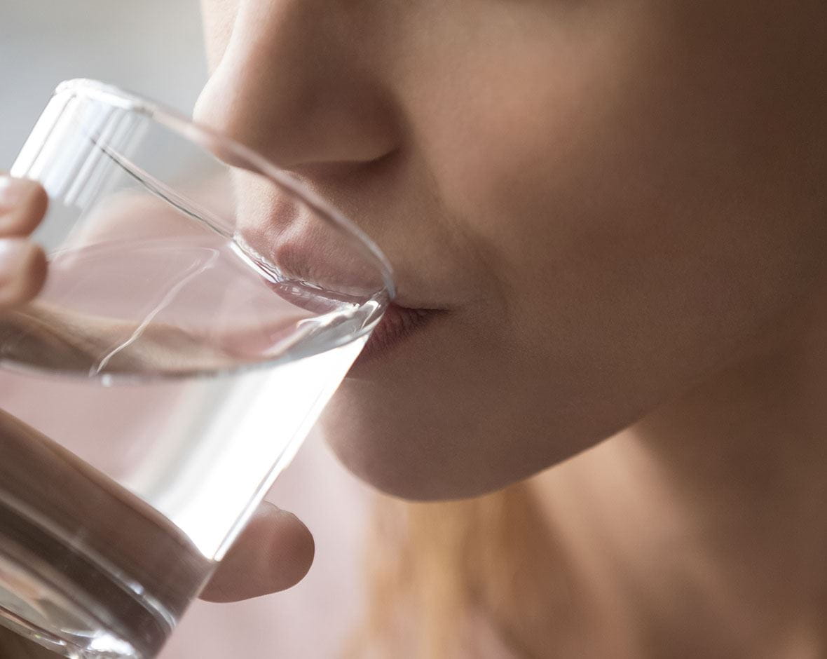 mujer bebiendo vaso de agua
