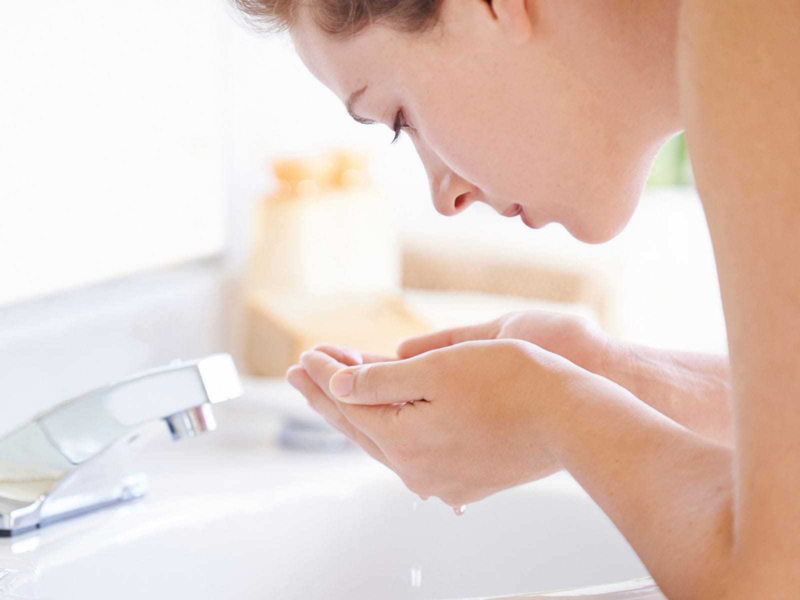 mujer lavando su rostro
