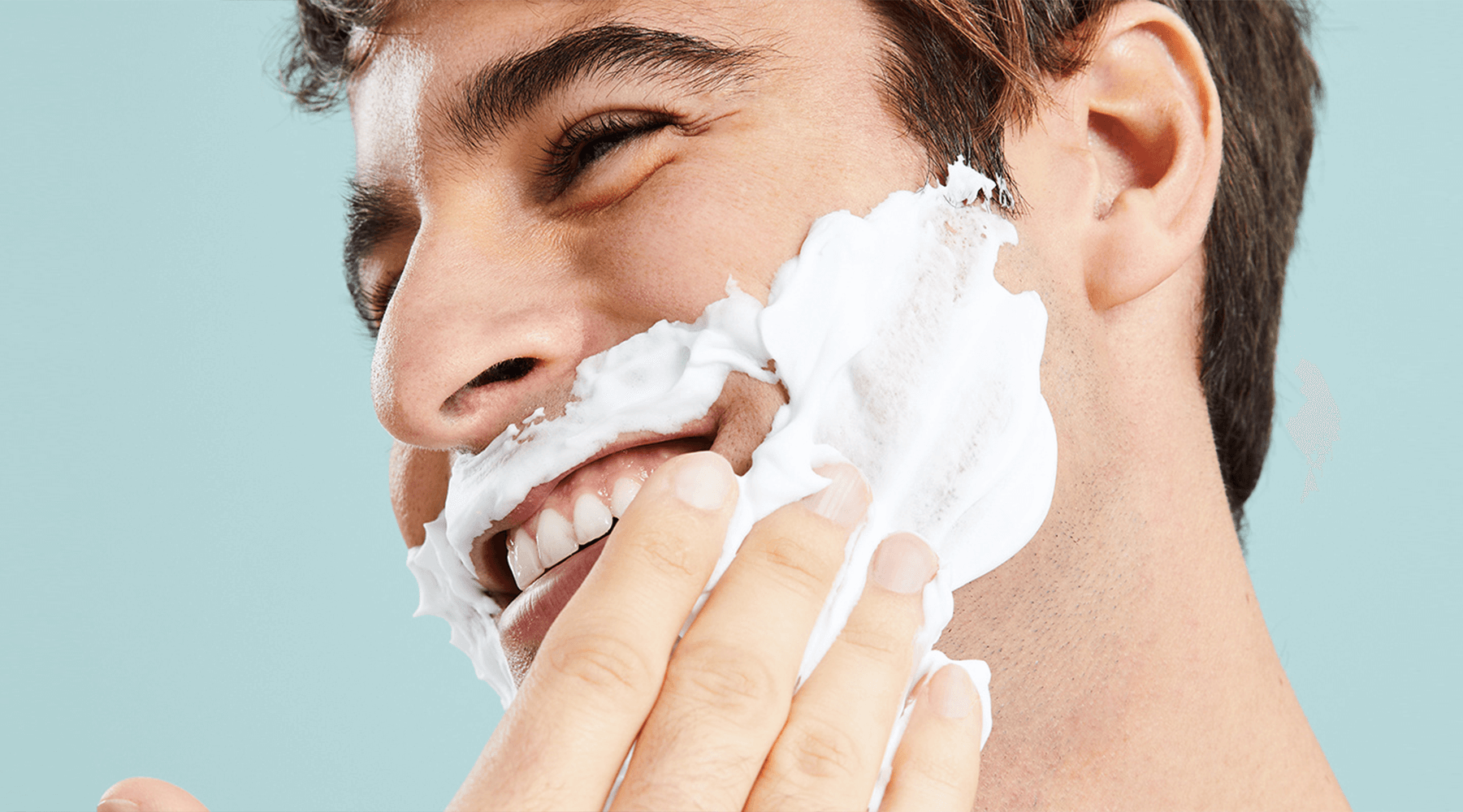 Persona colocandose espuma de afeitar sobre el rostro
