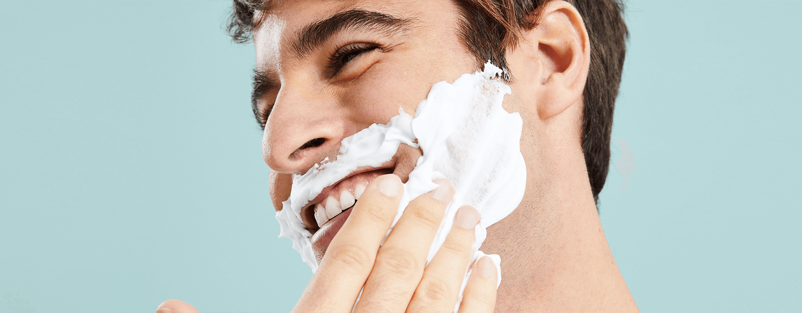 Persona colocandose espuma de afeitar sobre el rostro