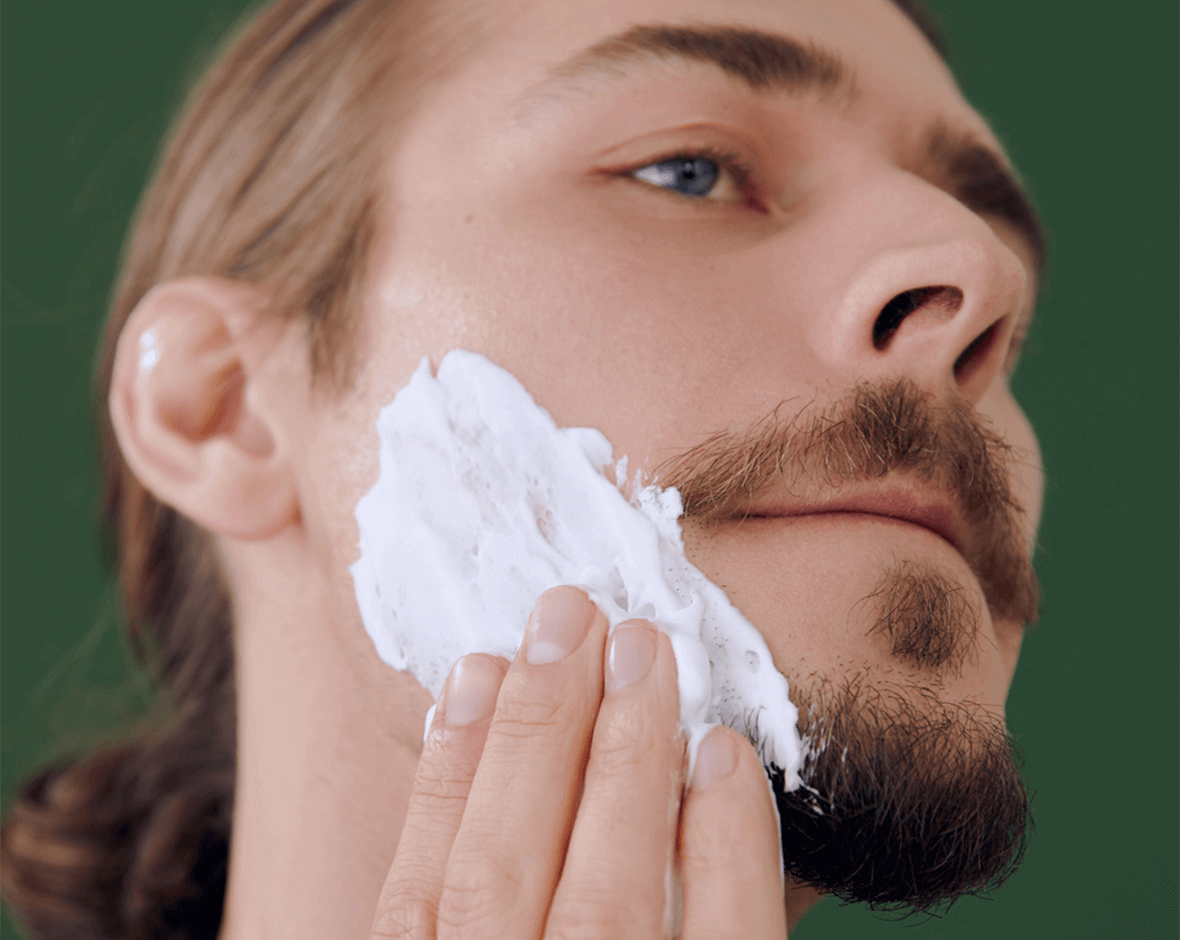 Persona aplicando espuma afeitar