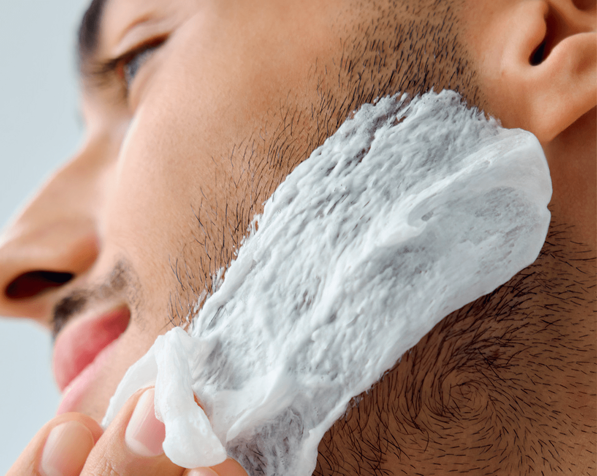 Persona preparando su barba para afeitarse