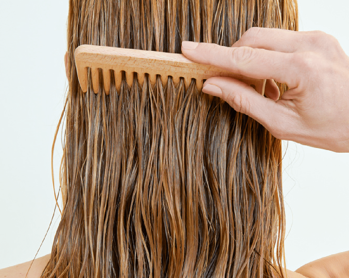 Persona poniéndose crema provitamina B5 en el pelo