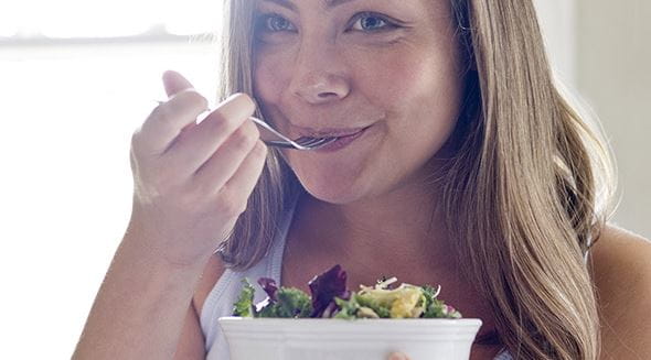 Eine Frau isst Salat aus einer Schüssel
