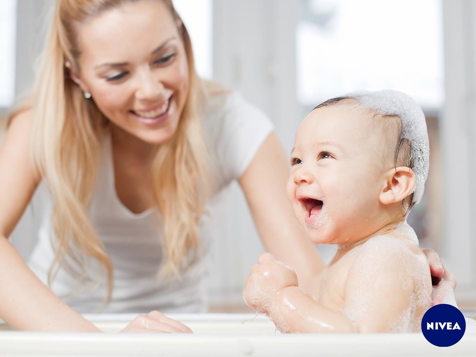 Ein Baby mit Shampoo im Haar neben seiner Mutter