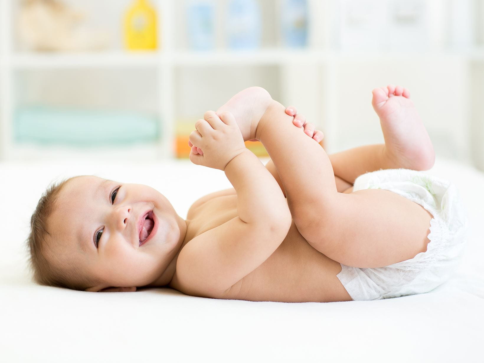 Ein lachendes Baby mit Windel