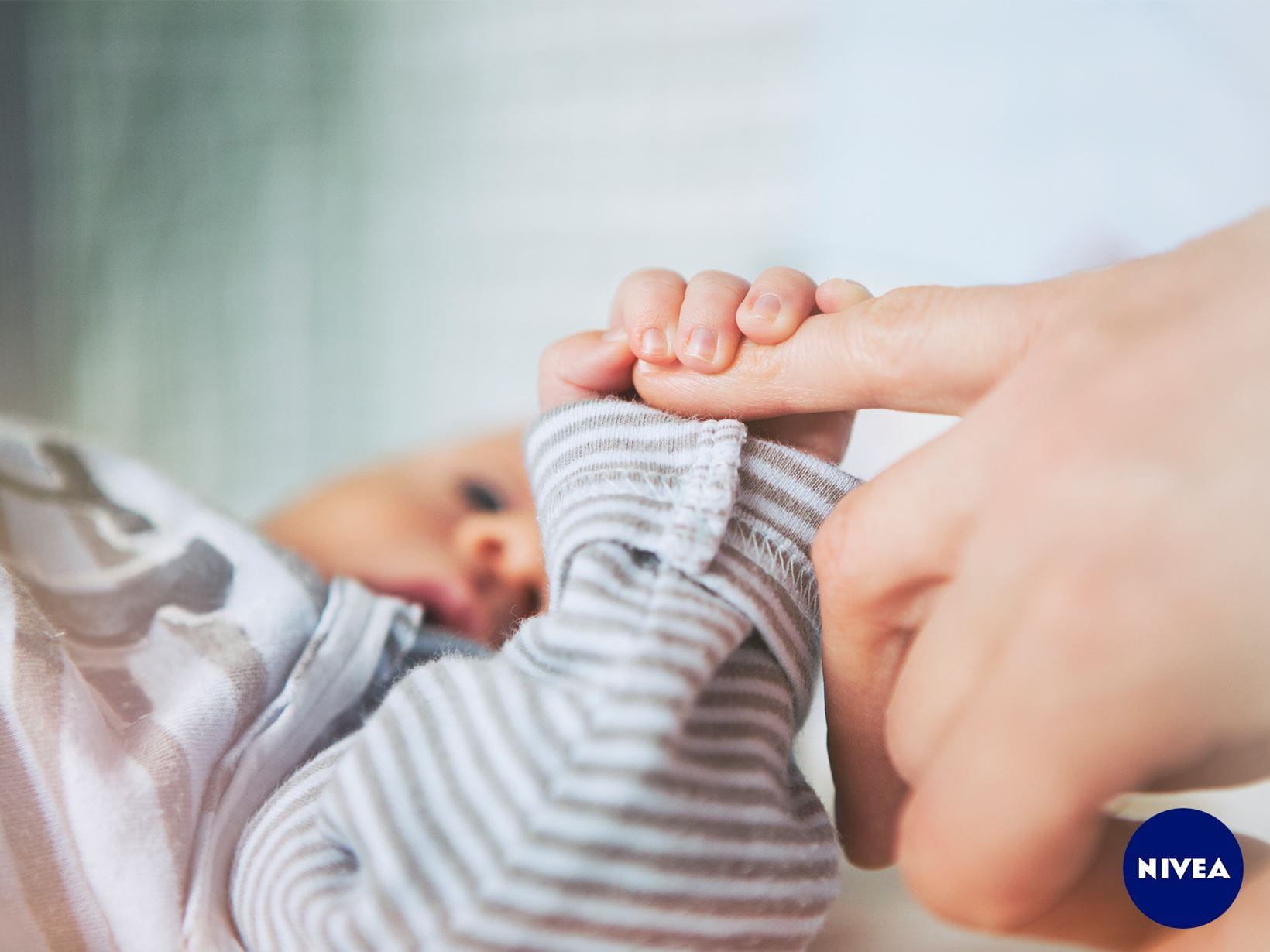 Ein Baby hält den Finger seiner Mutter