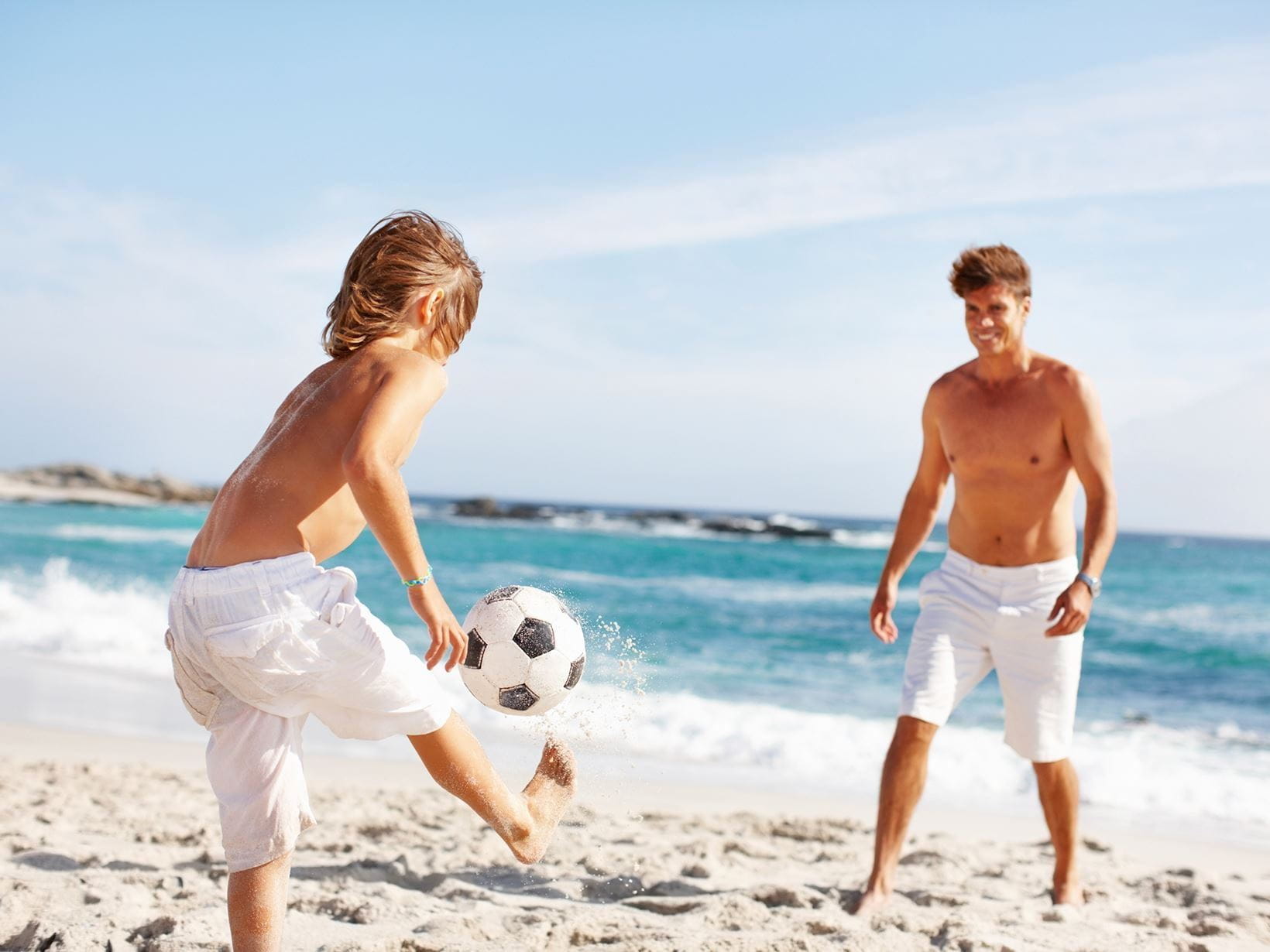 игра на плажа, две момчета ритат топка на плажа