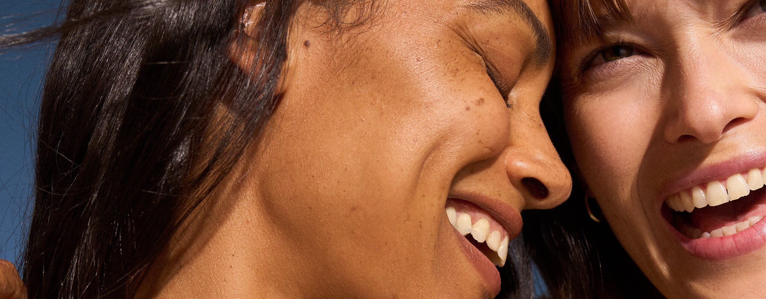 A view of two people's faces closely touching together while smiling.