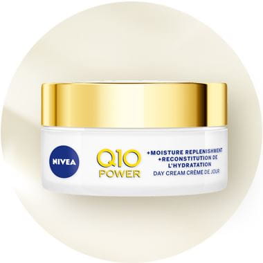 View of a Nivea Q10 Power face moisture replenishment day cream against a beige background.