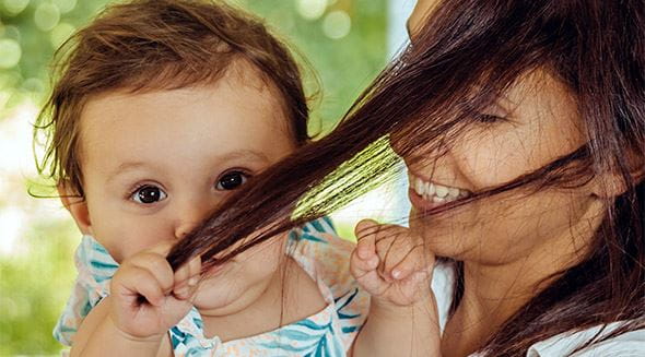 Baby zieht Mama an den Haaren
