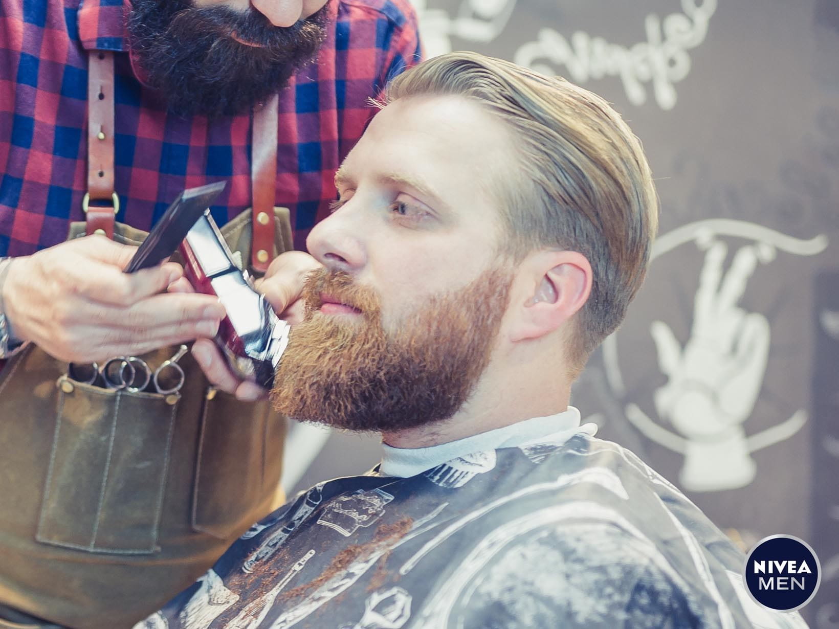 Mann lässt sich im Barber-Shop den Bart trimmen