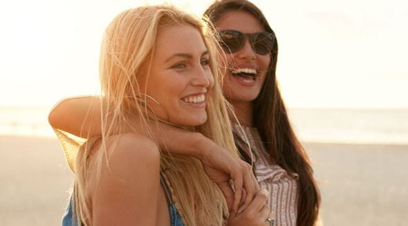 Zwei Frauen lachend am Strand